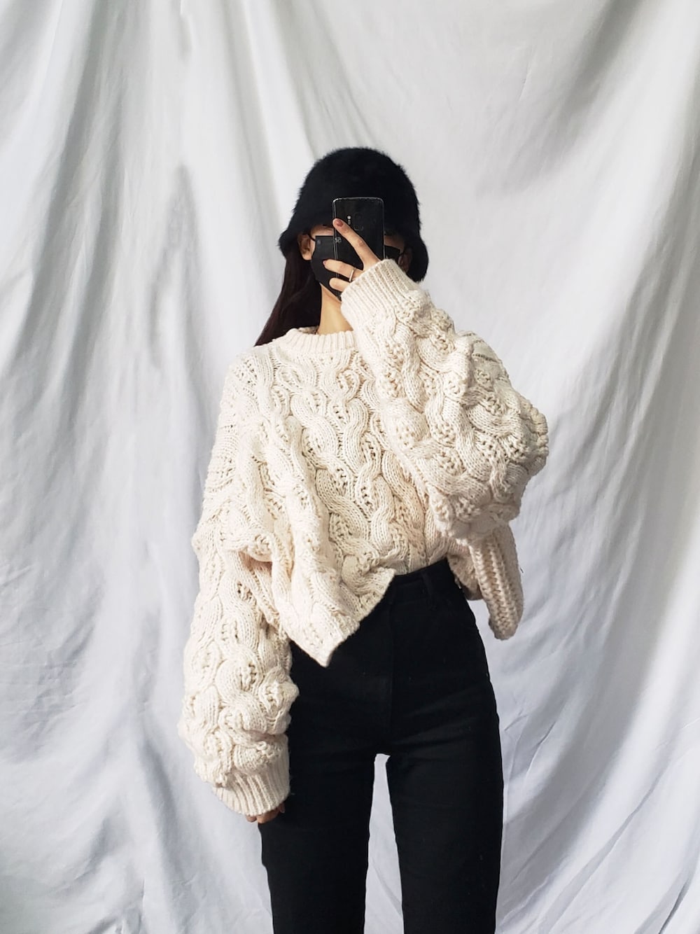 ホワイト系のニット/セーター、ブラック系のハットを着用したレディースの冬コーディネートの1枚目の写真