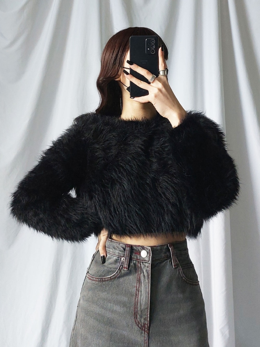 ブラック系のニット/セーター、ブラック系のデニムパンツを着用したレディースの冬コーディネートの1枚目の写真