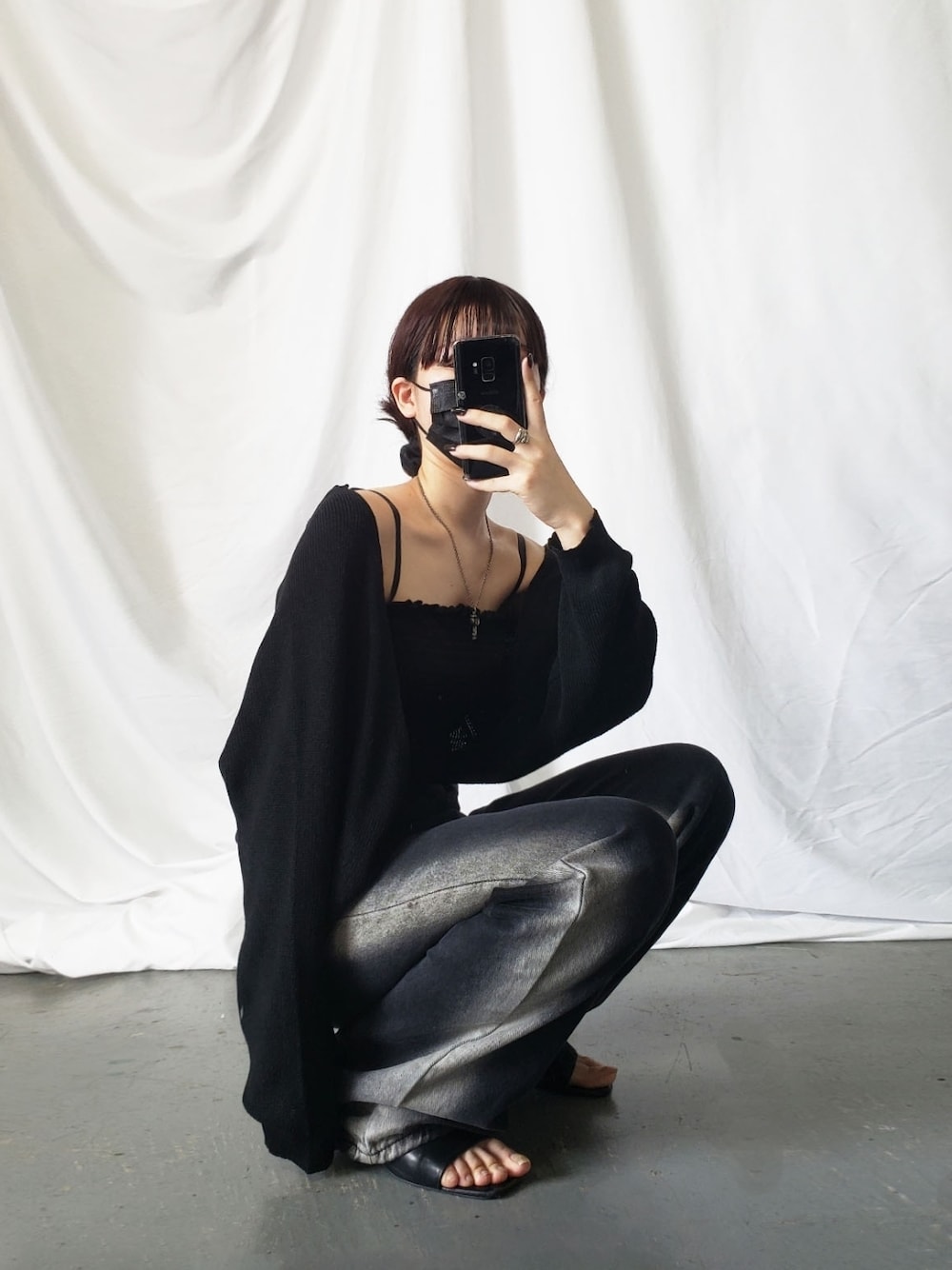 ブラック系のデニムパンツを着用したレディースの夏コーディネートの1枚目の写真