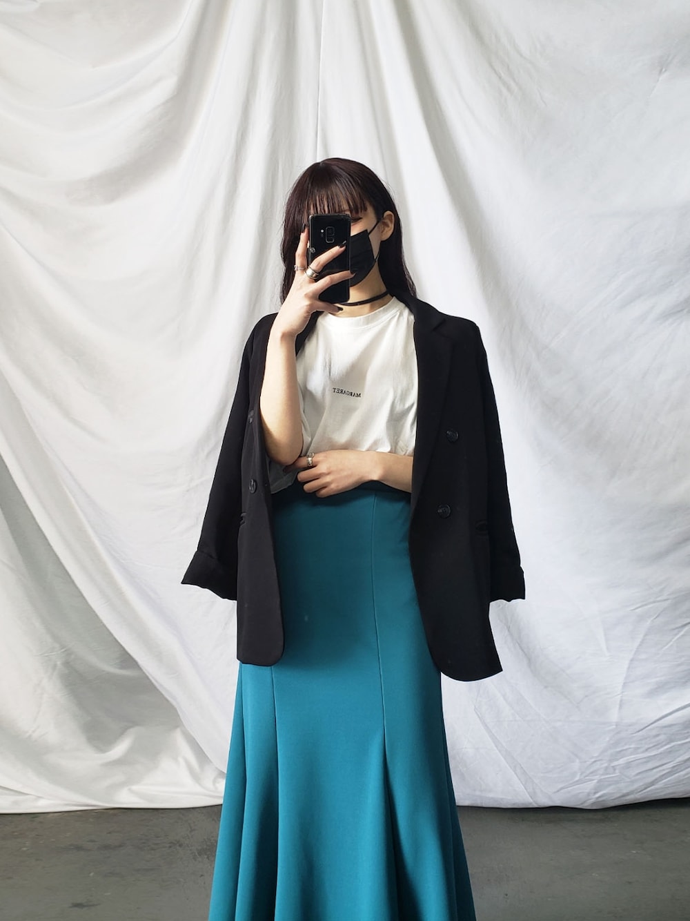 ブラック系のテーラードジャケット、ブルー系のスカートを着用したレディースの冬コーディネートの2枚目の写真