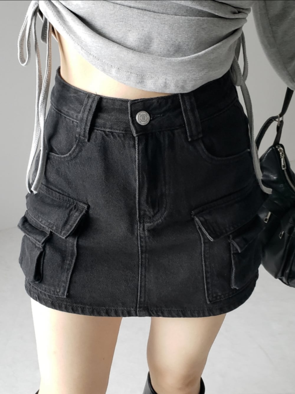 ブラック系のデニムスカートを着用したレディースの夏コーディネートの1枚目の写真