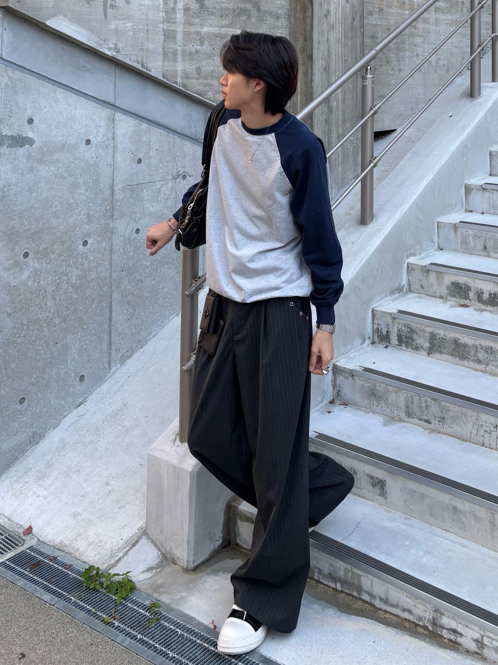 ブルー系のスウェット、グレー系のスラックス、ブラック系のスニーカーを着用したメンズの秋コーディネートの1枚目の写真