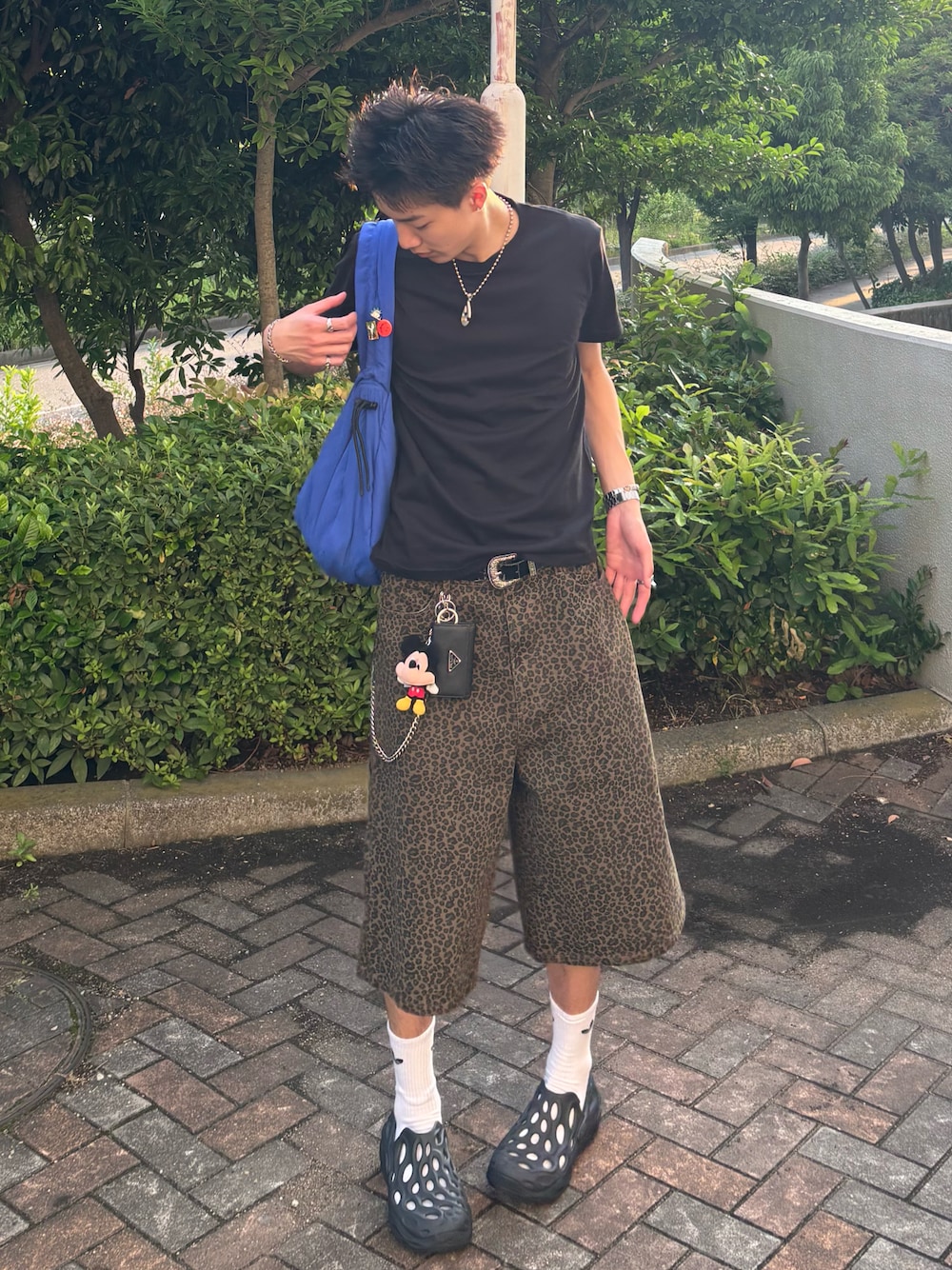 ブラック系のTシャツ/カットソー、ブラウン系のデニムパンツ、ブラック系のサンダルを着用したメンズの夏コーディネートの1枚目の写真