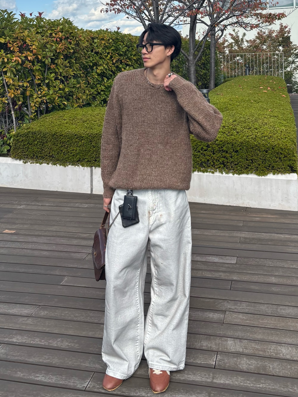 ブラウン系のニット/セーター、ホワイト系のデニムパンツ、ブラウン系のハンドバッグを着用したメンズの秋コーディネートの1枚目の写真