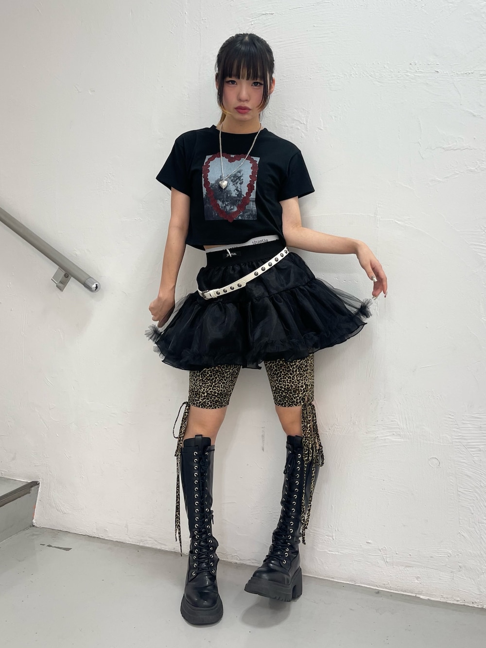 ブラック系のスカート、ブラウン系のその他パンツ、ブラック系のブーツを着用したレディースの夏コーディネートの1枚目の写真