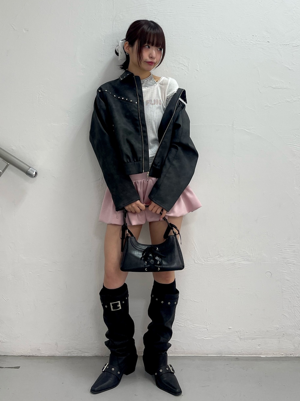 ブラック系のブルゾン、ホワイト系のTシャツ/カットソー、ピンク系のスカートを着用したレディースの冬コーディネートの1枚目の写真