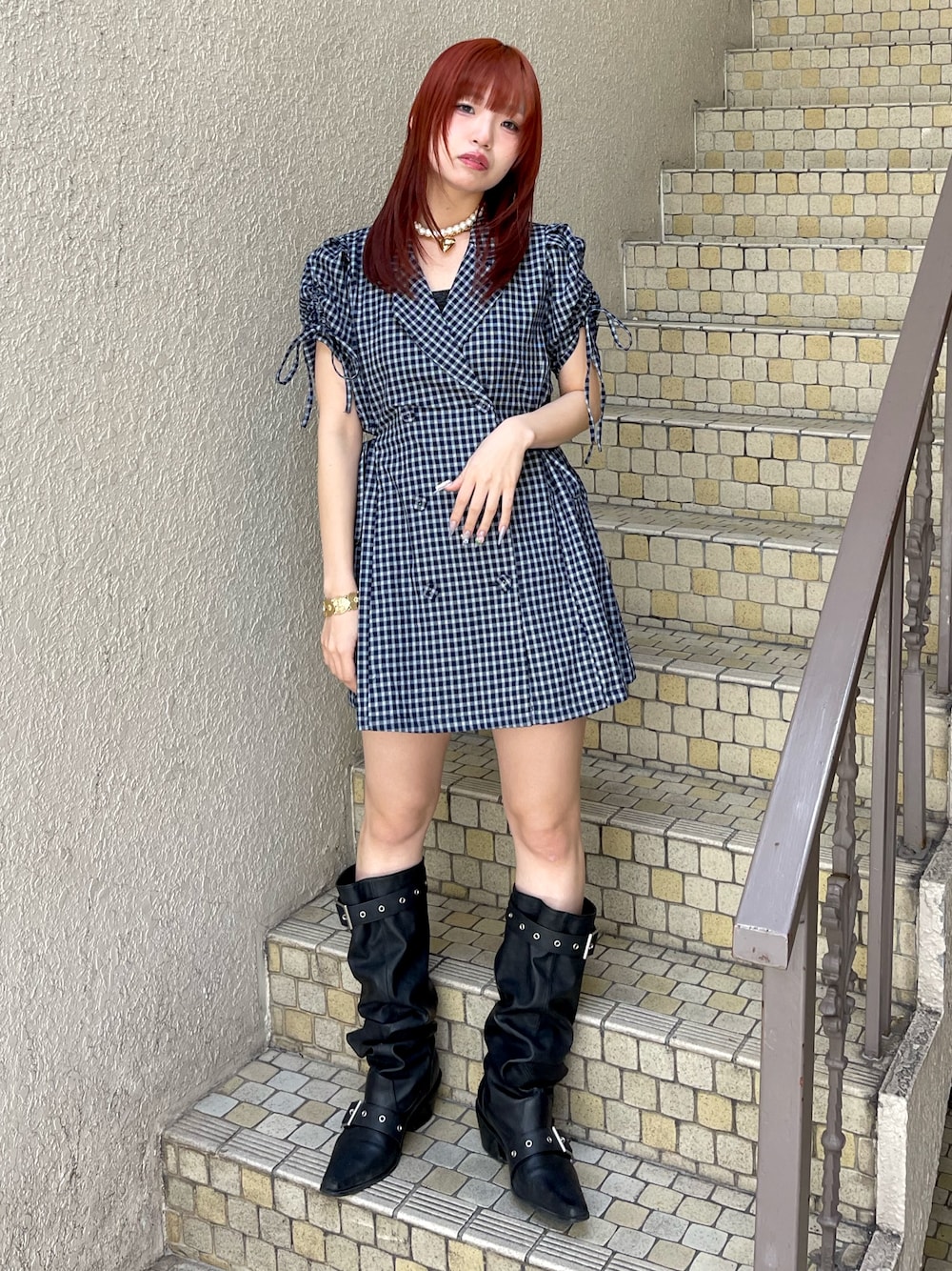 ブルー系のワンピース、ブラック系のブーツ、ゴールド系のネックレスを着用したレディースの春コーディネートの1枚目の写真