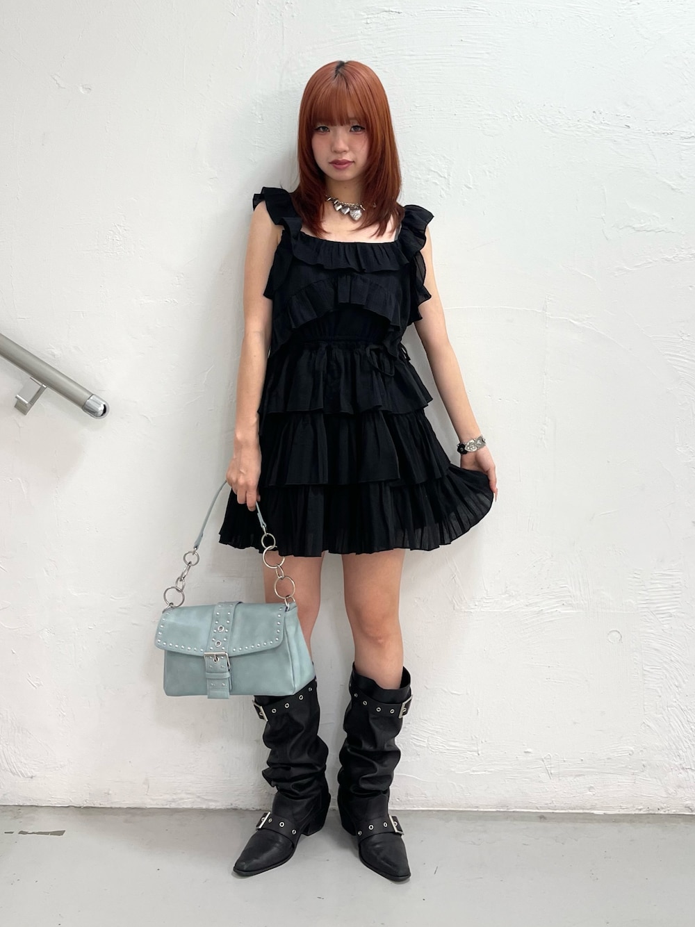 ブラック系のワンピース、ブルー系のハンドバッグ、ブラック系のブーツを着用したレディースの夏コーディネートの1枚目の写真
