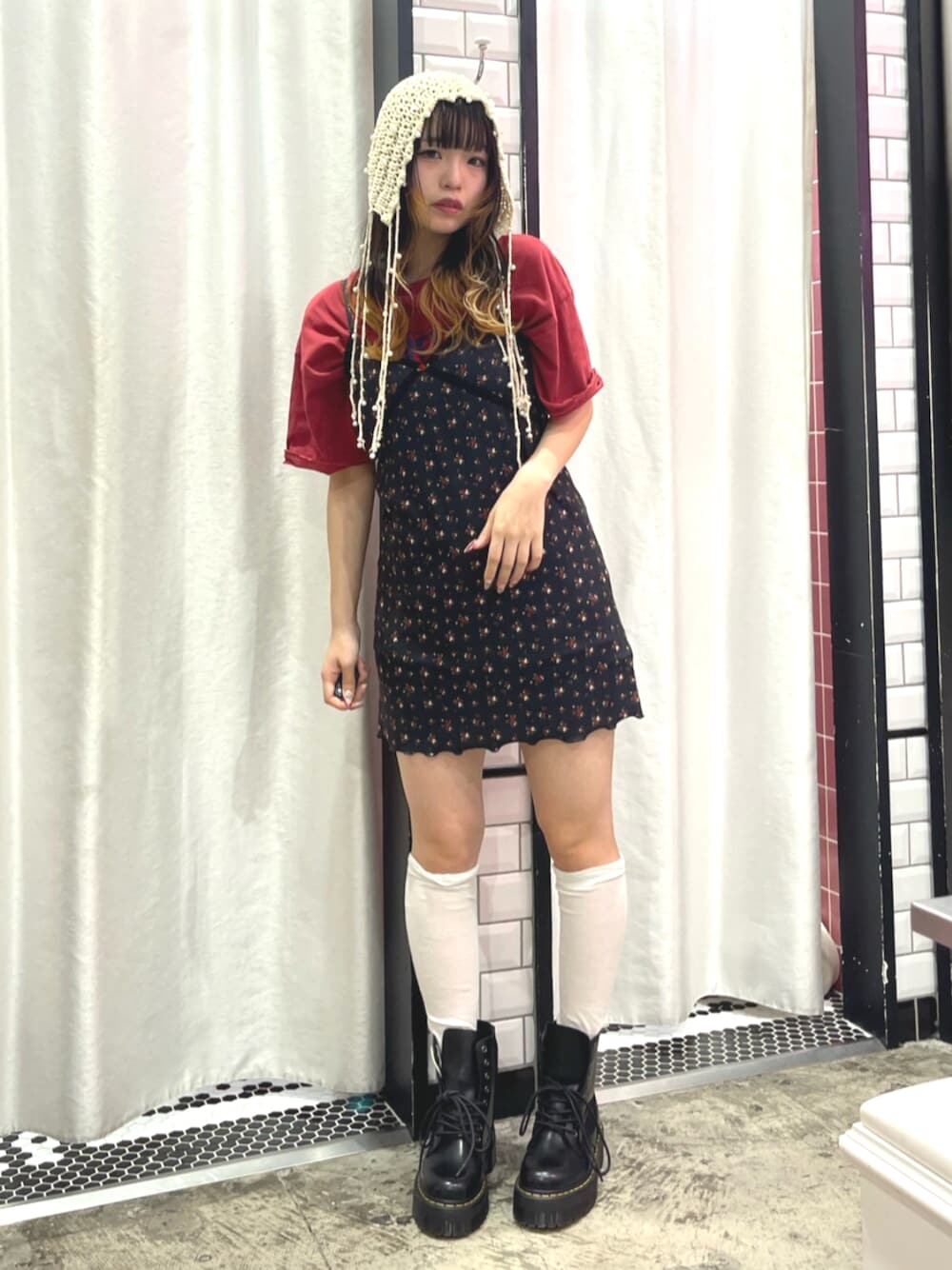 ブラック系のワンピース、レッド系のTシャツ/カットソー、ブラック系のブーツを着用したレディースの春コーディネートの1枚目の写真