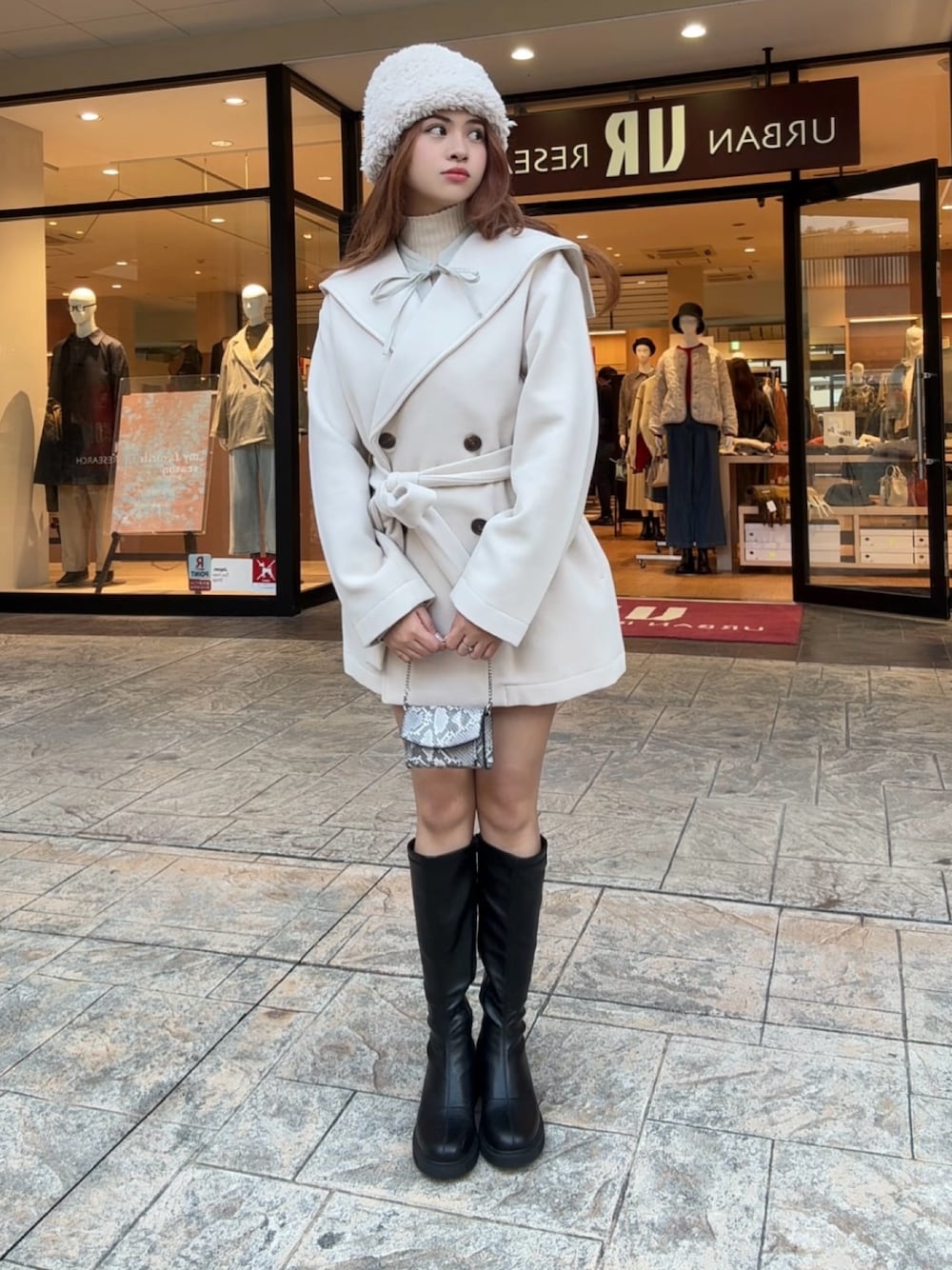 ホワイト系のニット/セーター、ブラック系のブーツ、その他のショルダーバッグを着用したレディースの秋コーディネートの1枚目の写真