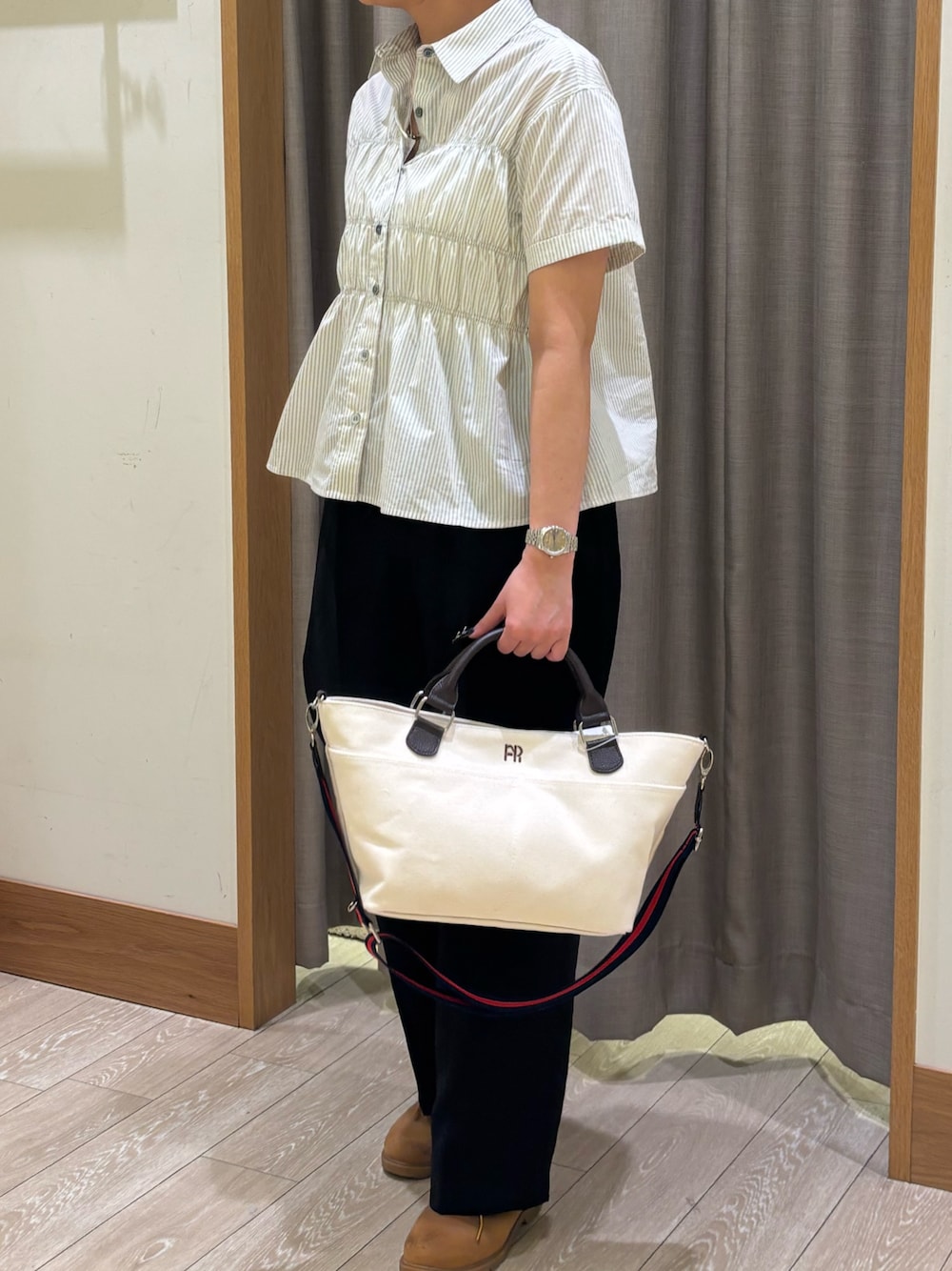 ベージュ系のシャツ/ブラウス、ブラック系のスラックスを着用したレディースの春コーディネートの1枚目の写真