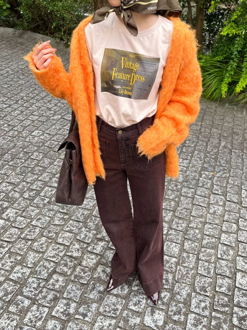 ブラウン系のデニムパンツを着用したレディースの秋コーディネートの1枚目の写真