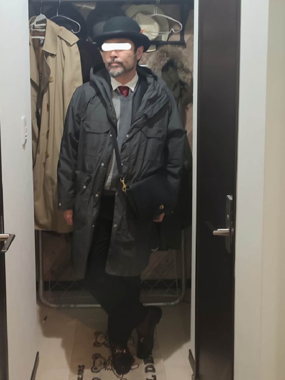 ブラック系のマウンテンパーカー、ブラック系のスーツセット、グレー系のベストを着用したメンズの春コーディネートの1枚目の写真