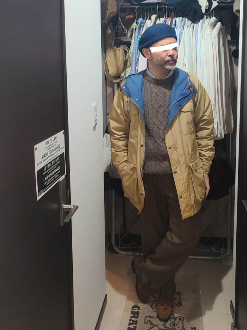 ベージュ系のマウンテンパーカー、ブラウン系のスラックス、ベージュ系のローファーを着用したメンズの冬コーディネートの1枚目の写真