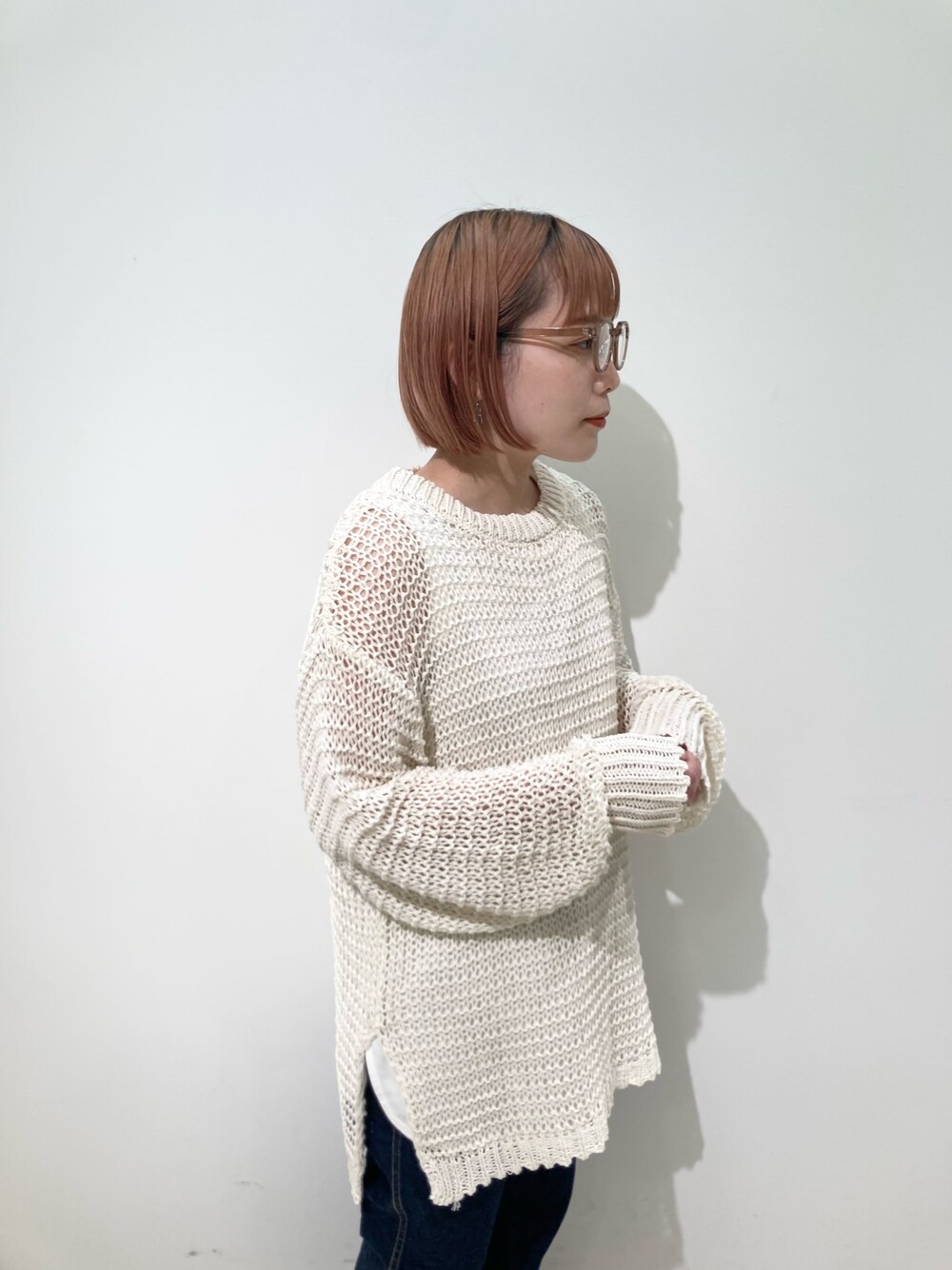 ブルー系のトートバッグ、ホワイト系のニット/セーター、ホワイト系のタンクトップを着用したレディースの春コーディネートの3枚目の写真