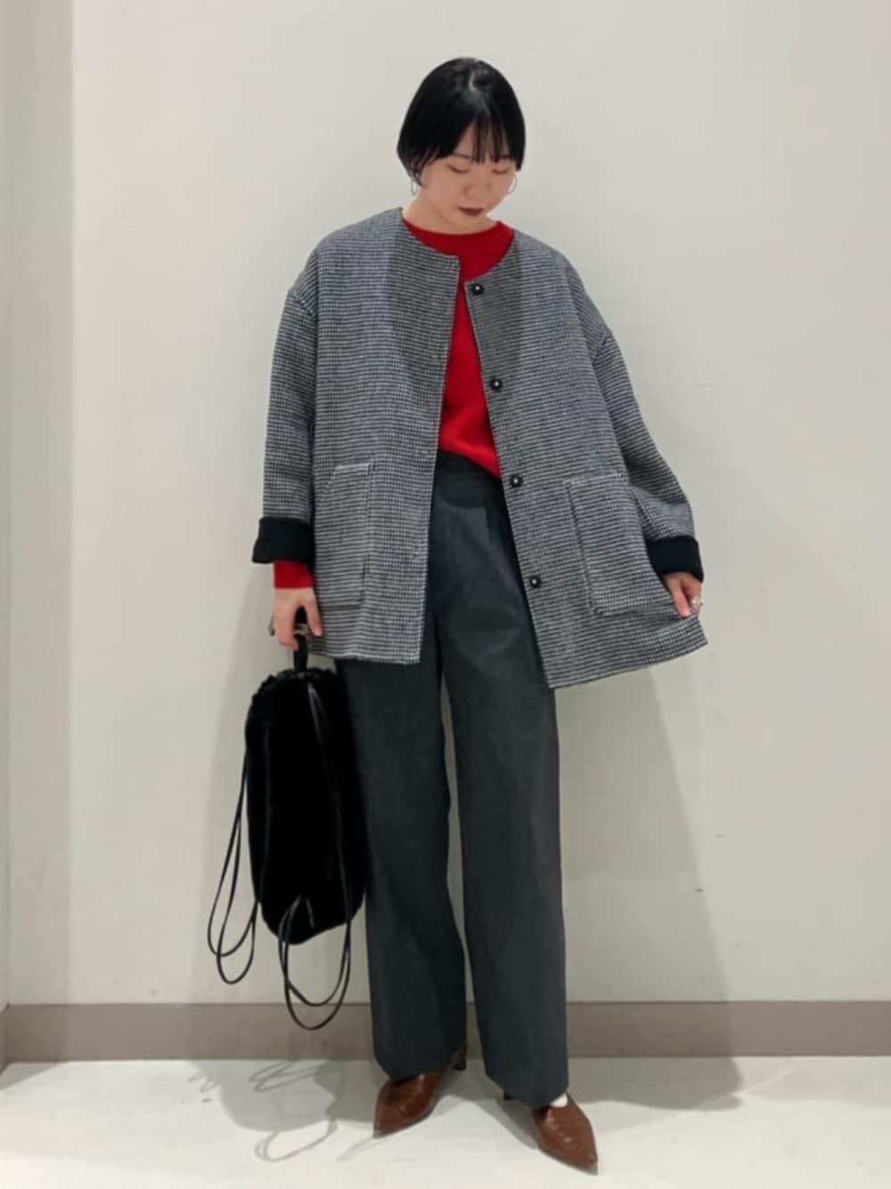 レッド系のニット/セーター、ブラック系のノーカラーコート、ブラック系のその他パンツを着用したレディースの秋コーディネートの1枚目の写真