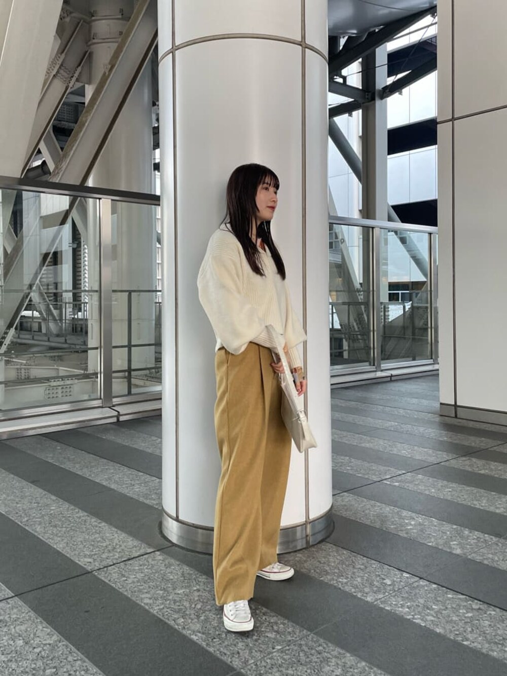 ホワイト系のハンドバッグ、イエロー系のその他パンツ、ホワイト系のニット/セーターを着用したレディースの冬コーディネートの1枚目の写真