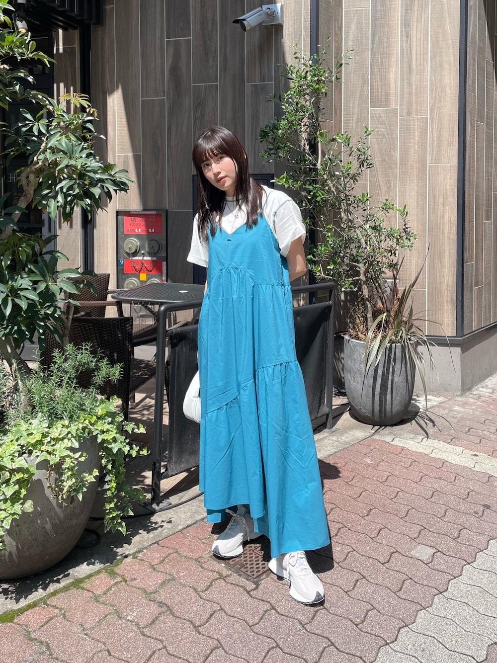 ブルー系のワンピース、ホワイト系のTシャツ/カットソー、シルバー系のネックレスを着用したレディースの春コーディネートの1枚目の写真