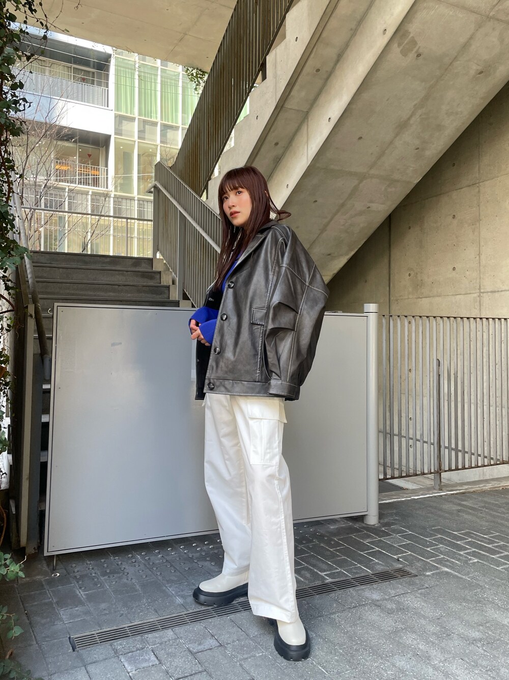 グレー系のブルゾン、ブルー系のニット/セーター、ホワイト系のカーゴパンツを着用したレディースの冬コーディネートの1枚目の写真
