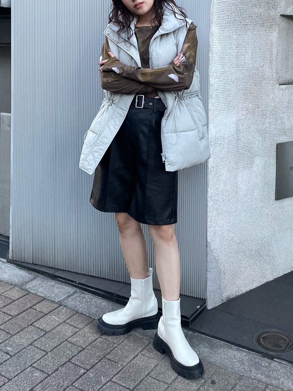 ホワイト系のTシャツ/カットソー、グレー系のダウンベスト、ブラック系のその他パンツを着用したレディースの秋コーディネートの1枚目の写真