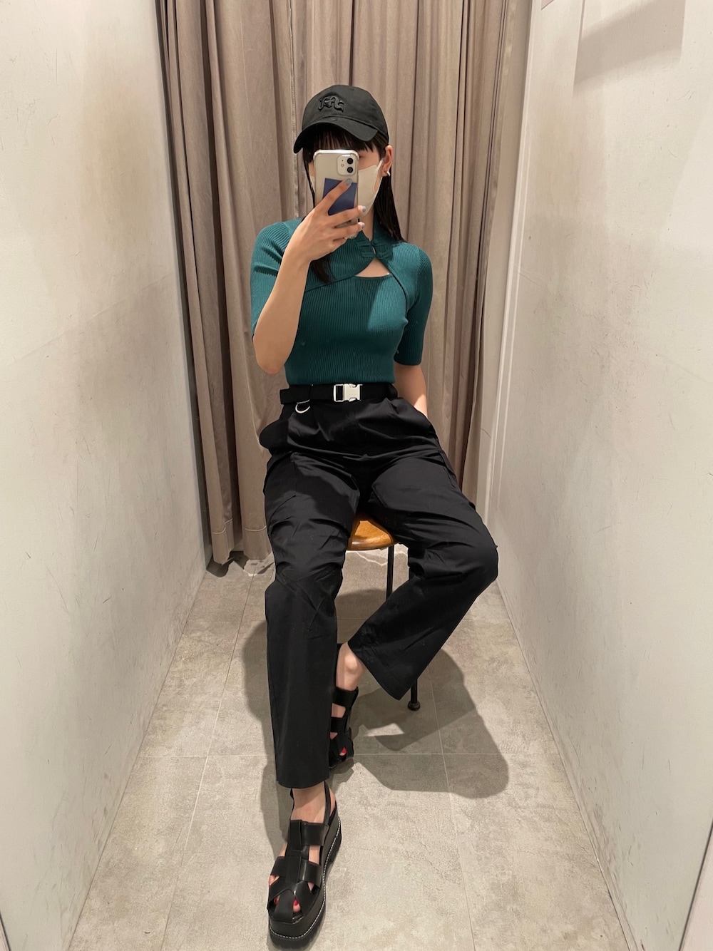 グリーン系のニット/セーター、ブラック系のカーゴパンツ、ブラック系のサンダルを着用したレディースの春コーディネートの1枚目の写真