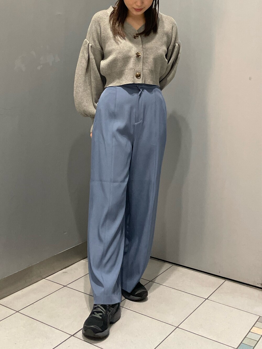 グレー系のカーディガン/ボレロ、ブルー系のスラックスを着用したレディースの冬コーディネートの1枚目の写真