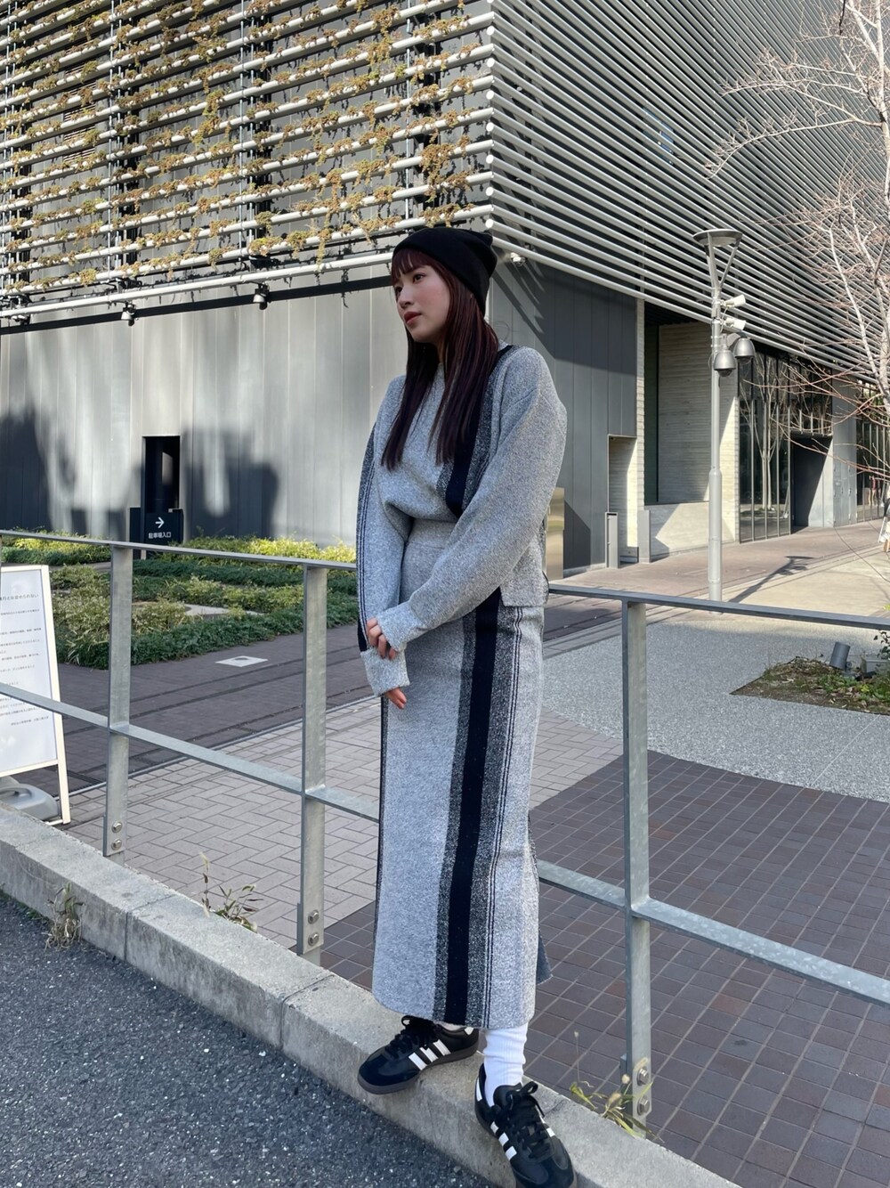 グレー系のニット/セーター、グレー系のスカートを着用したレディースの冬コーディネートの1枚目の写真