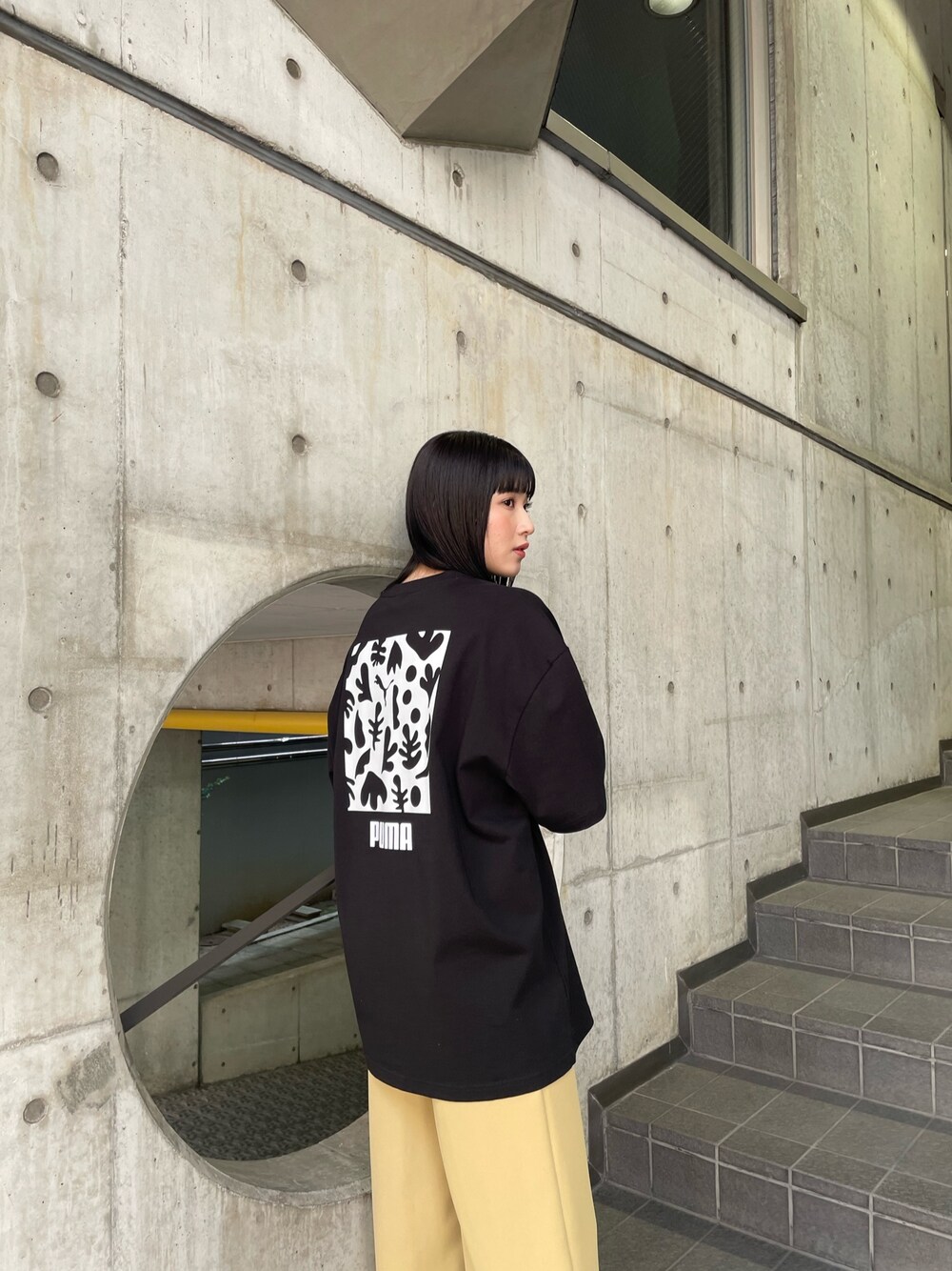 ブラック系のTシャツ/カットソー、イエロー系のスラックスを着用したレディースの春コーディネートの1枚目の写真