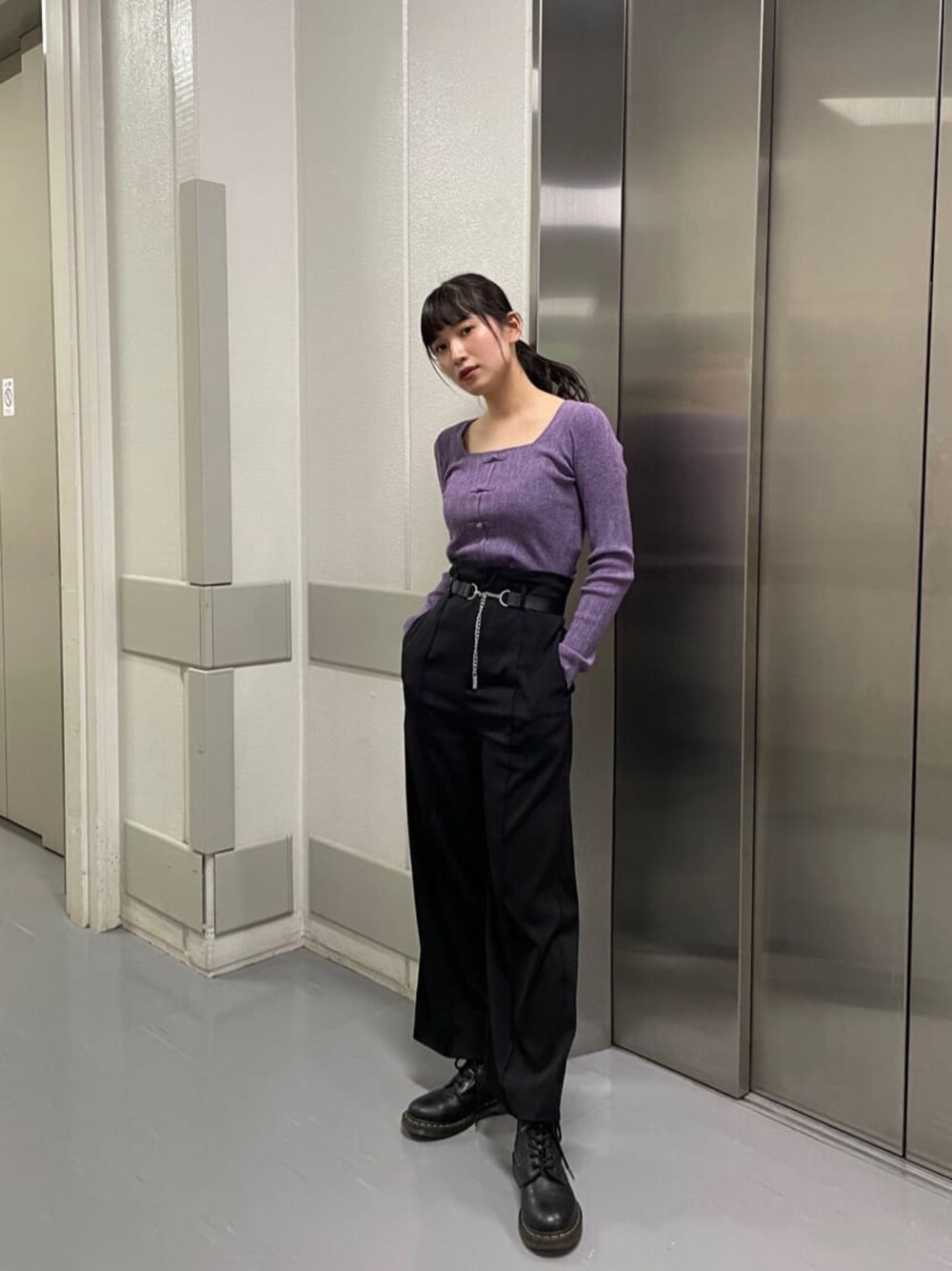パープル系のニット/セーター、ブラック系のスラックスを着用したレディースの秋コーディネートの1枚目の写真