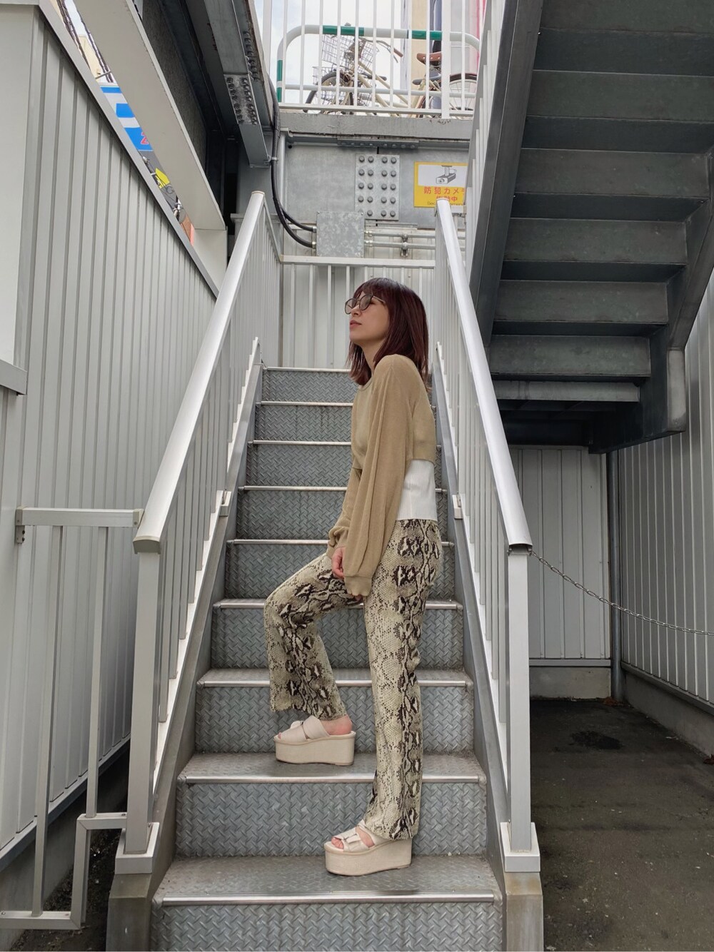 その他のスラックス、ベージュ系のニット/セーター、その他のサングラスを着用したレディースの春コーディネートの1枚目の写真