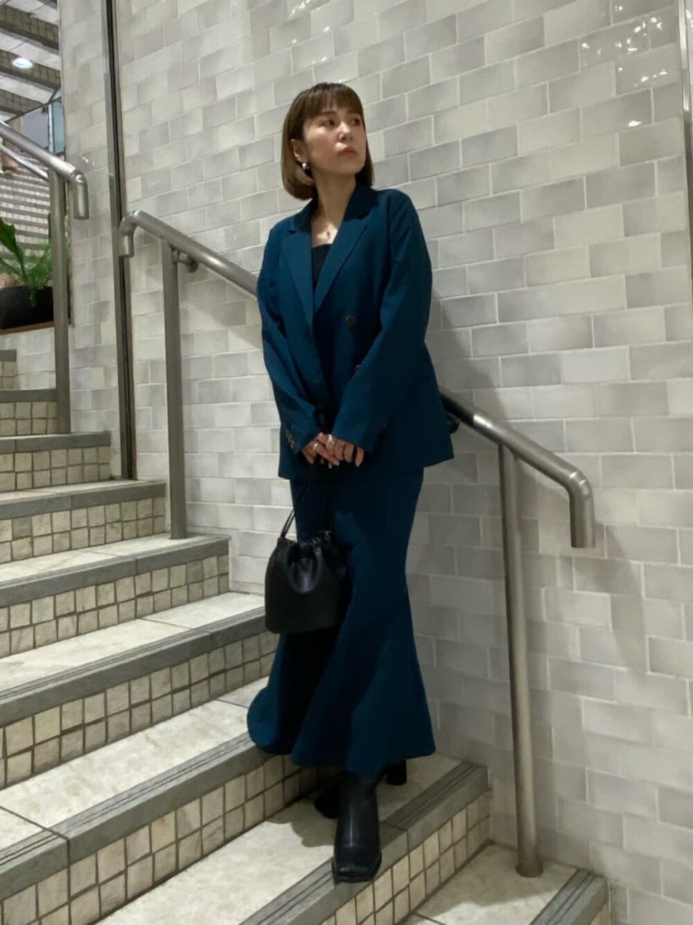 ブラック系のタンクトップ、グリーン系のテーラードジャケット、グリーン系のスカートを着用したレディースの夏コーディネートの1枚目の写真