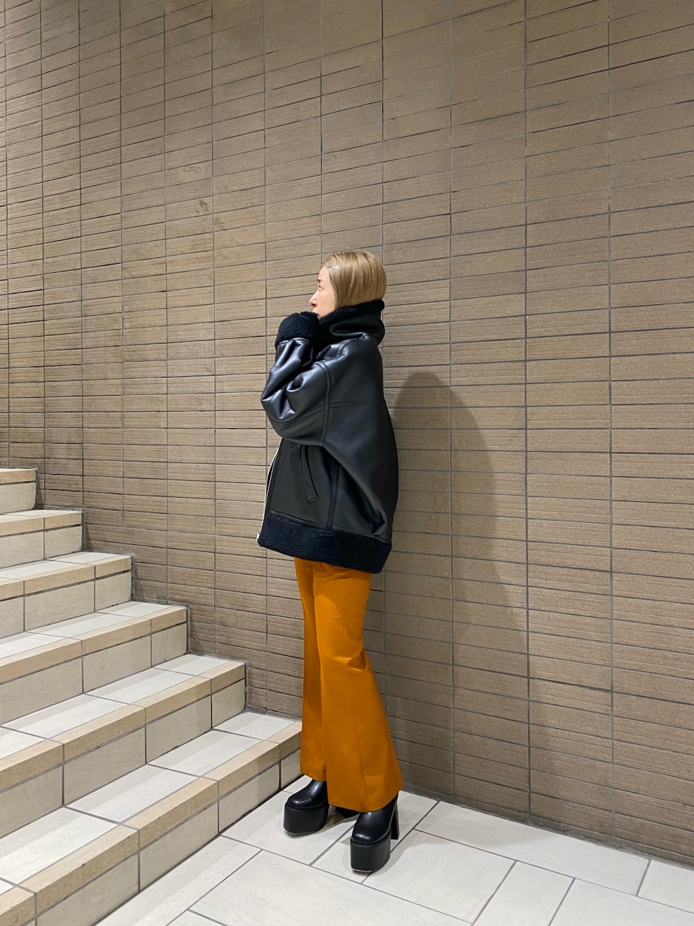 ブラック系のムートンコート、ホワイト系のTシャツ/カットソー、オレンジ系のその他パンツを着用したレディースの夏コーディネートの1枚目の写真