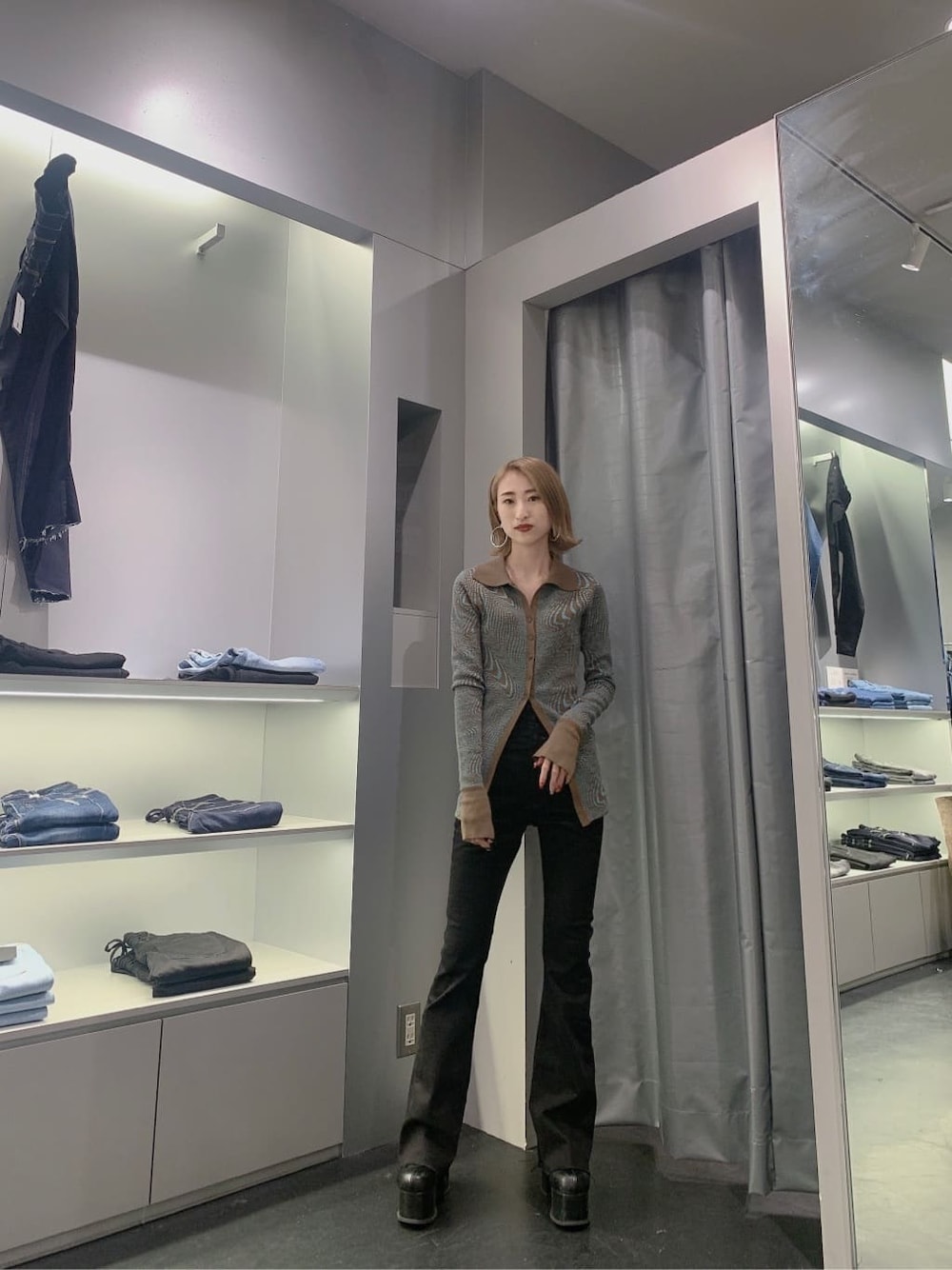 その他のカーディガン/ボレロ、ブラック系のブーツ、ブラック系のデニムパンツを着用したレディースの秋コーディネートの1枚目の写真