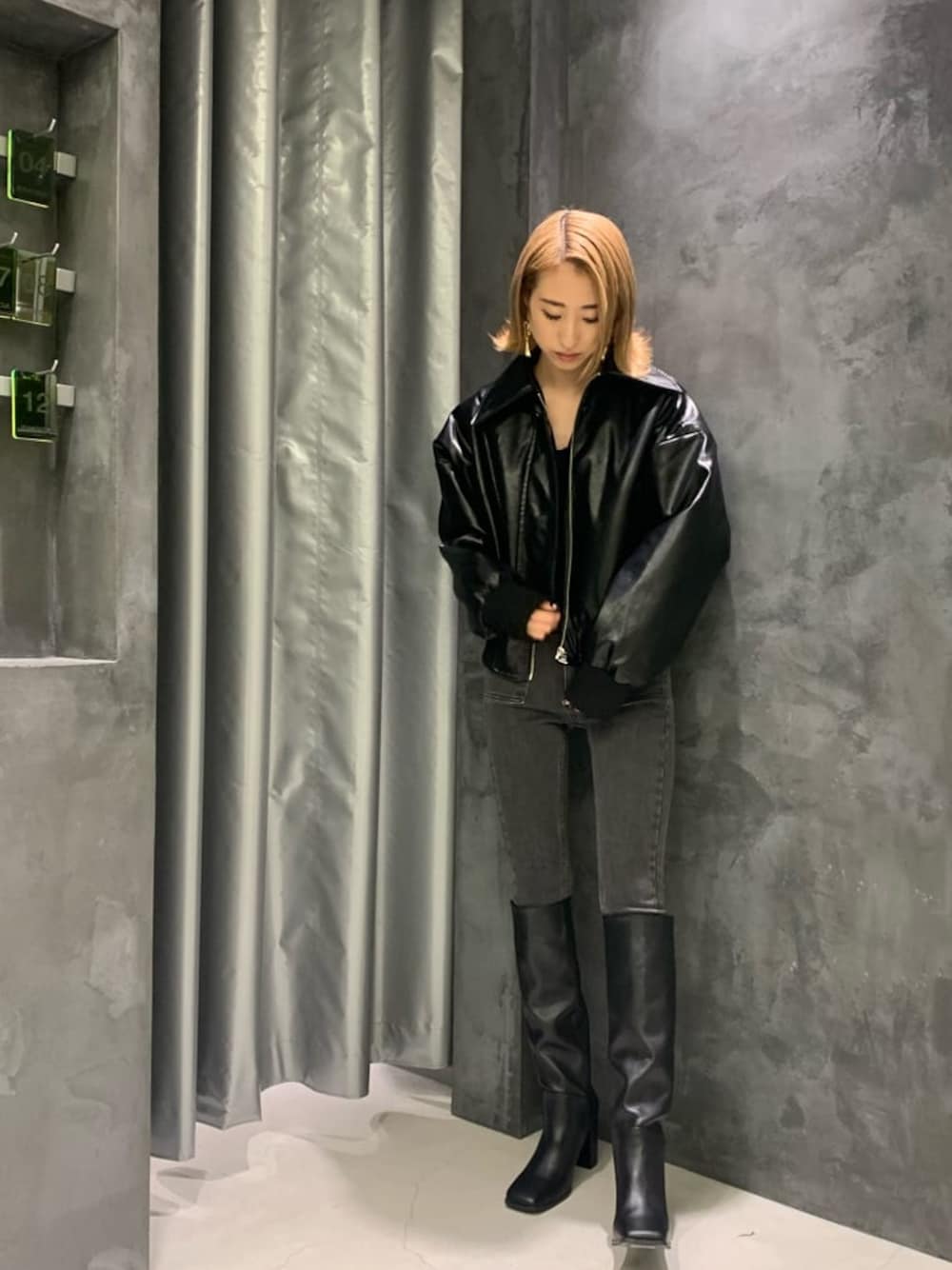 ブラック系のブーツ、グレー系のデニムパンツ、ブラック系のブルゾンを着用したレディースの秋コーディネートの1枚目の写真