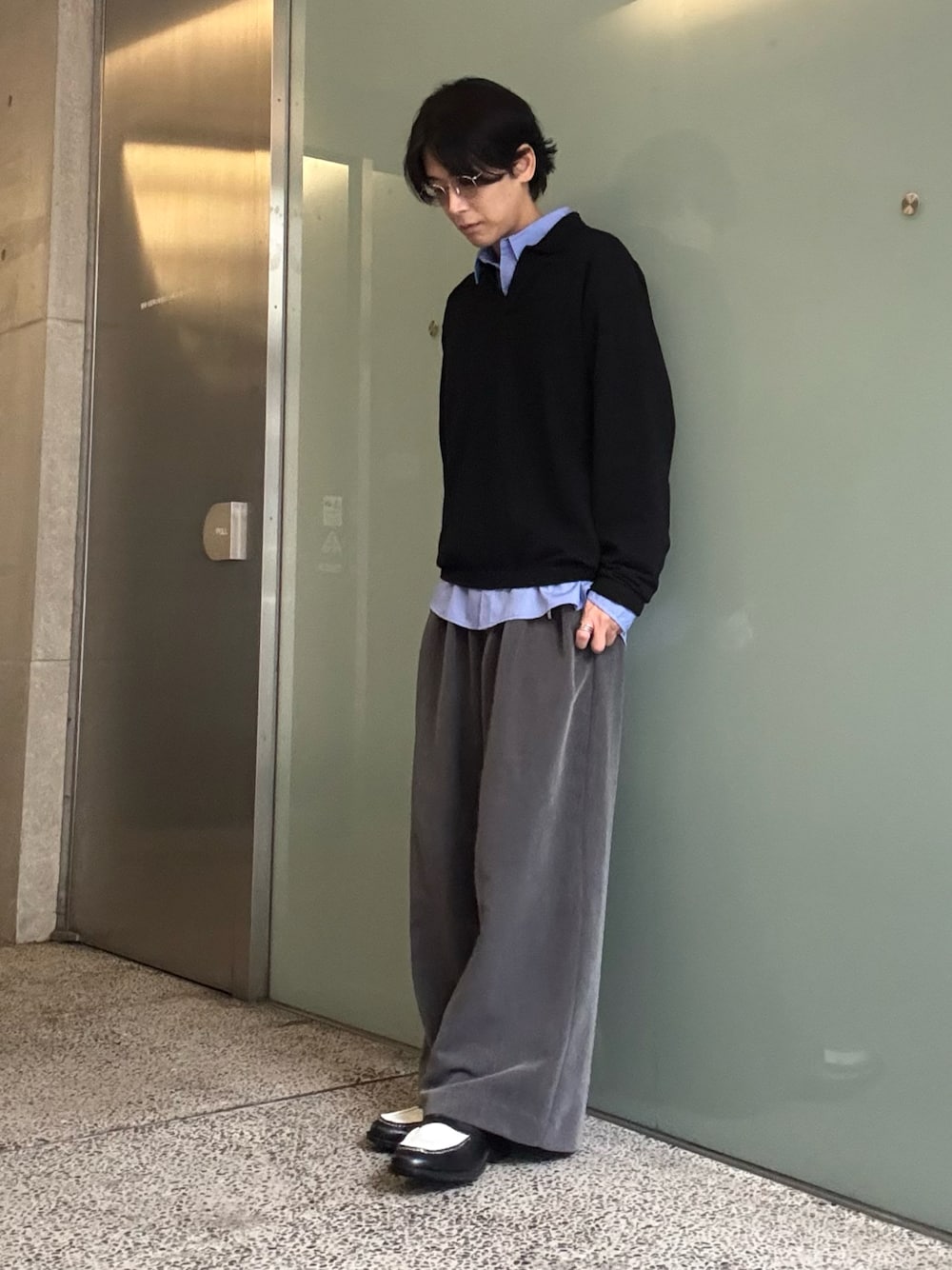 ブルー系のシャツ/ブラウス、グレー系のスラックス、ブラック系のニット/セーターを着用したメンズの秋コーディネートの1枚目の写真