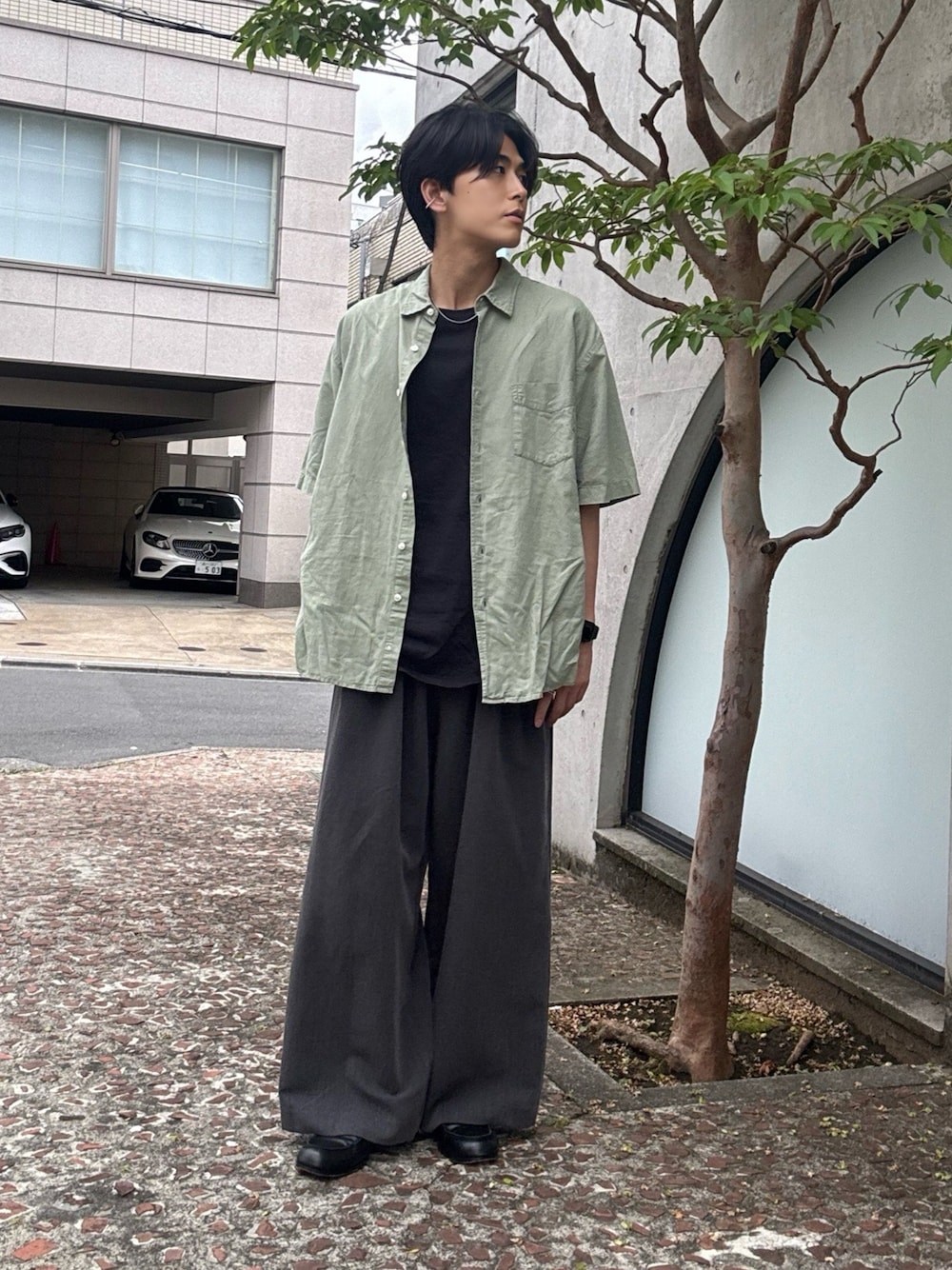 ブラック系のTシャツ/カットソー、グレー系のスラックス、ブラック系のローファーを着用したメンズの夏コーディネートの1枚目の写真