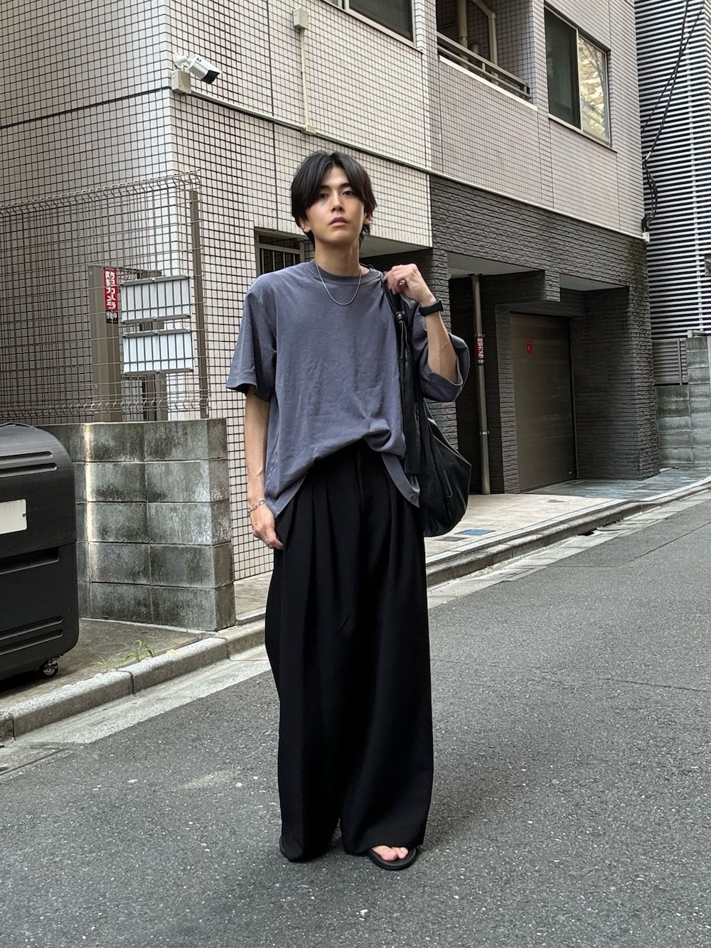 ブラック系のスラックス、ブラック系のサンダル、ブルー系のTシャツ/カットソーを着用したメンズの夏コーディネートの1枚目の写真