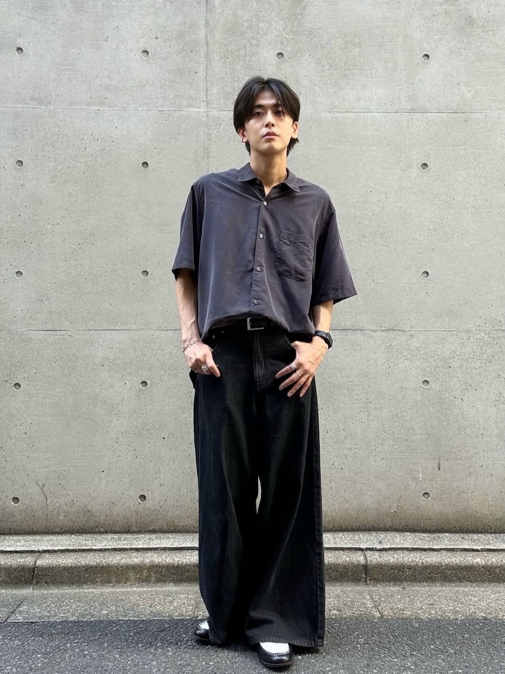ブラック系のデニムパンツ、ブラック系のシャツ/ブラウス、ブラウン系のローファーを着用したメンズの夏コーディネートの1枚目の写真