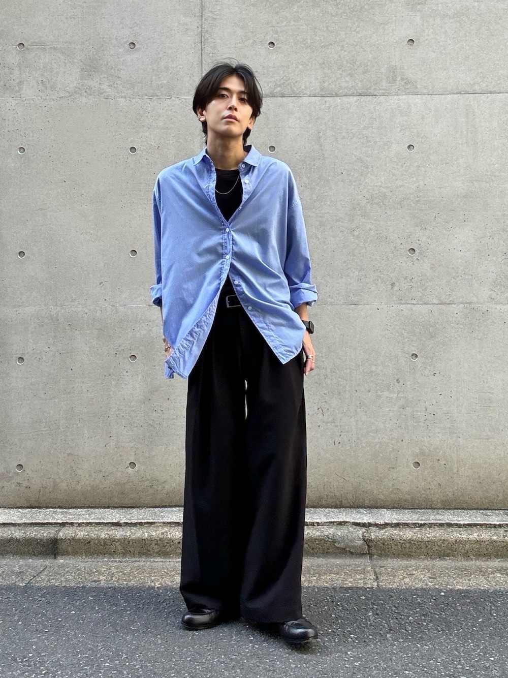 ブルー系のシャツ/ブラウス、ブラック系のTシャツ/カットソー、ブラック系のスラックスを着用したメンズの春コーディネートの1枚目の写真