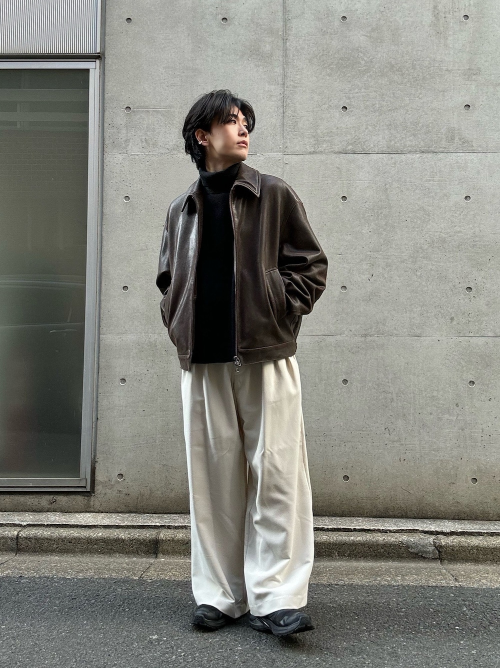 ブラック系のスニーカー、グレー系のニット/セーター、ホワイト系のスラックスを着用したメンズの冬コーディネートの1枚目の写真