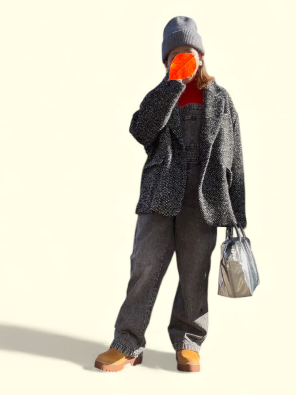 シルバー系のボストンバッグ、ベージュ系のブーツ、オレンジ系のニット/セーターを着用したレディースの冬コーディネートの1枚目の写真