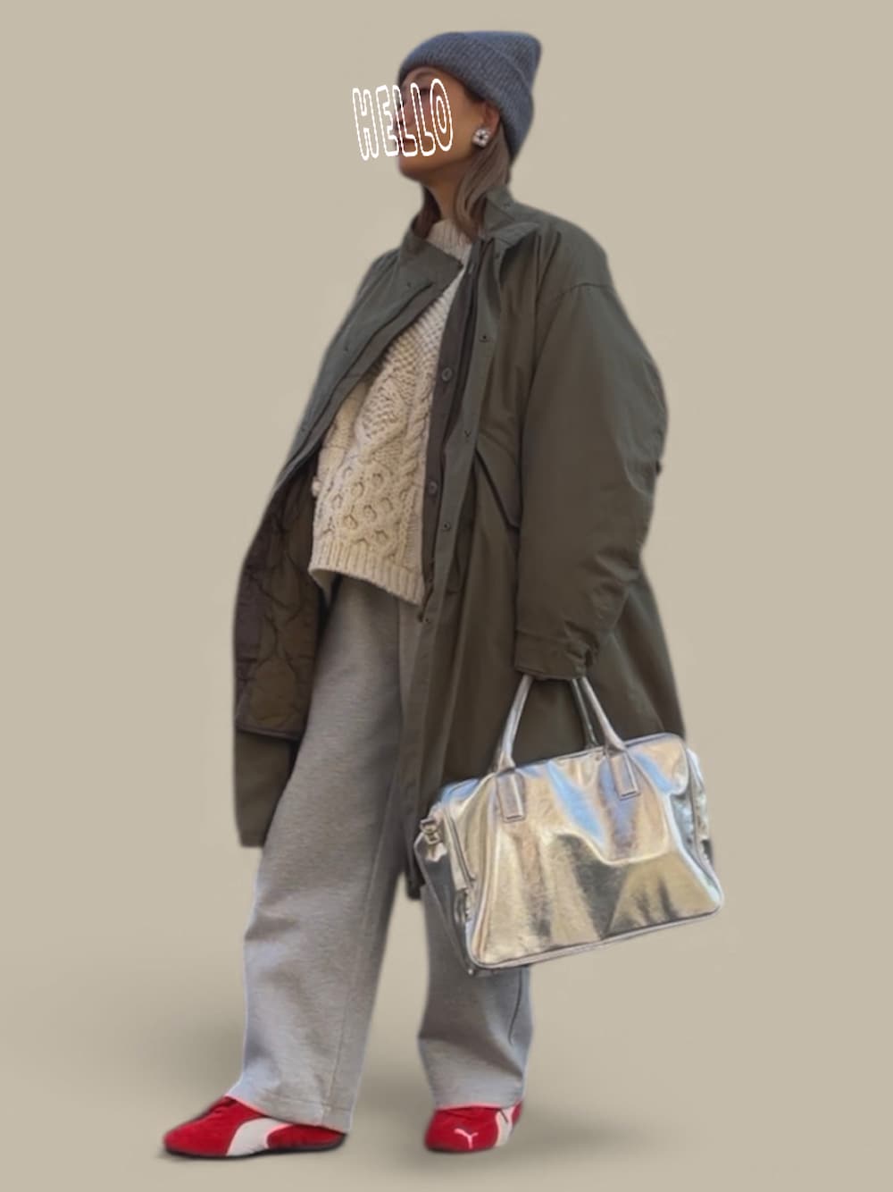 グリーン系のミリタリージャケット、ホワイト系のニット/セーター、シルバー系のボストンバッグを着用したレディースの冬コーディネートの1枚目の写真