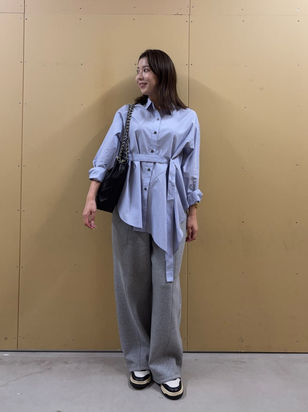 ブルー系のシャツ/ブラウス、グレー系のその他パンツ、ブラック系のショルダーバッグを着用したレディースの秋コーディネートの1枚目の写真