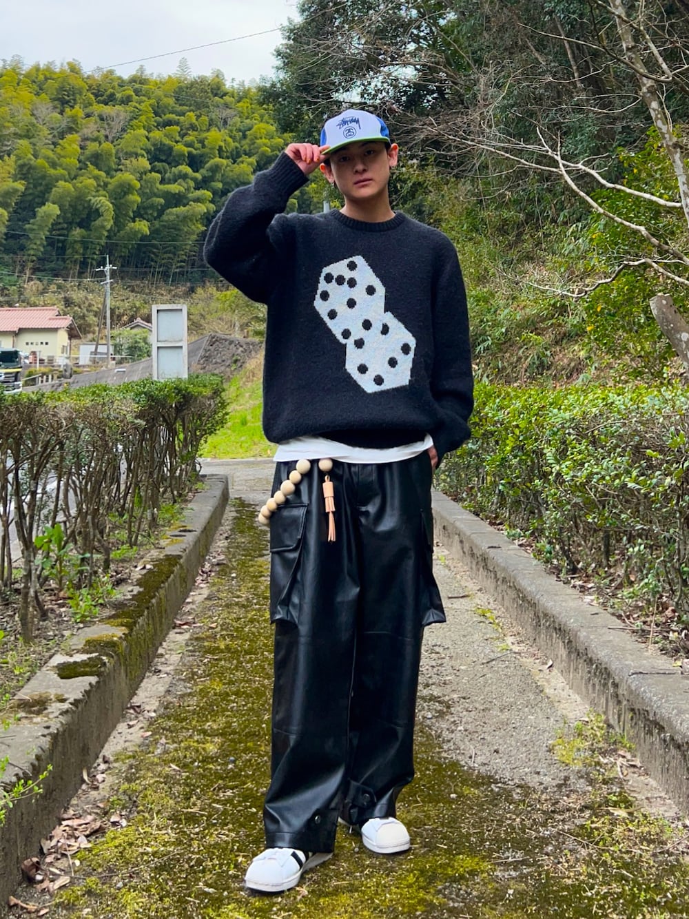 ブラック系のニット/セーター、ブラック系のカーゴパンツ、ホワイト系のスニーカーを着用したメンズの春コーディネートの1枚目の写真