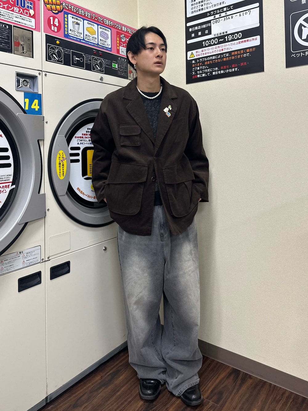 ブラウン系のテーラードジャケット、ブラック系のニット/セーター、グレー系のデニムパンツを着用したメンズの秋コーディネートの1枚目の写真