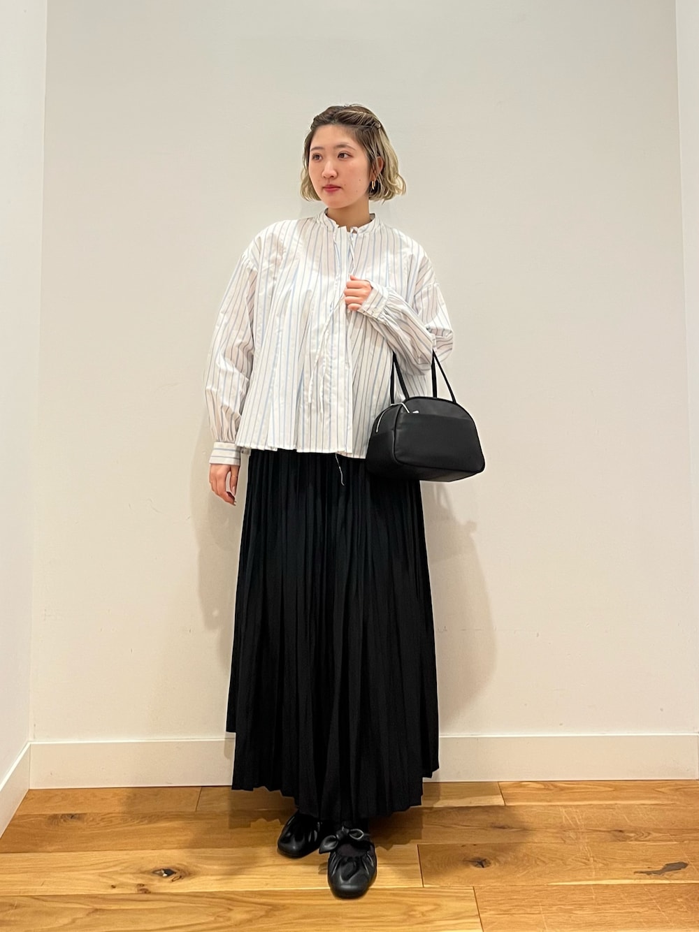 ブラック系のスカート、ホワイト系のシャツ/ブラウスを着用したレディースの春コーディネートの1枚目の写真