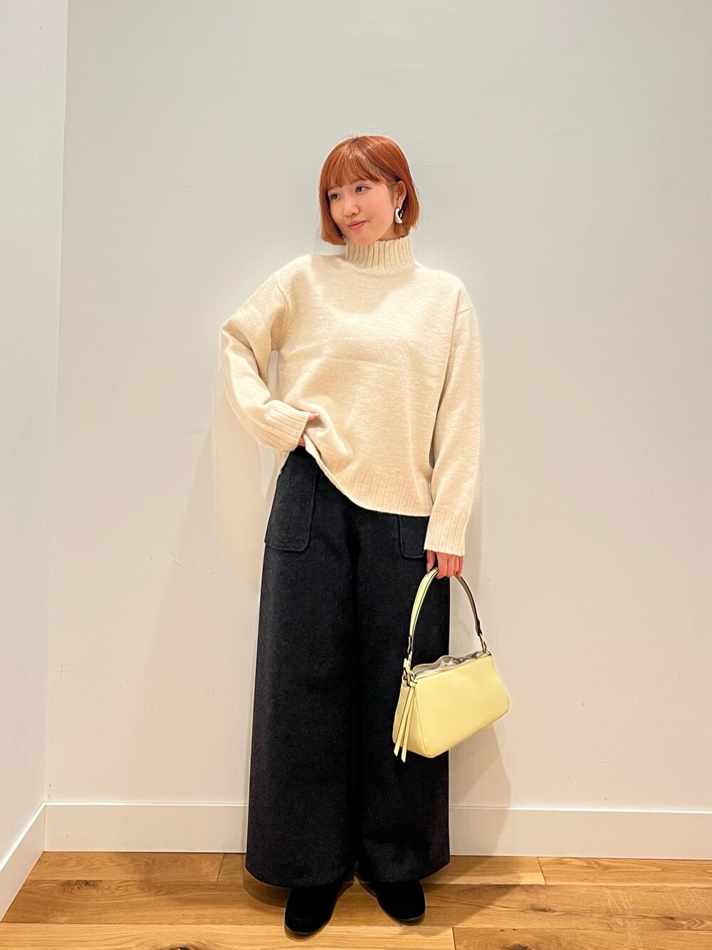 ホワイト系のニット/セーター、イエロー系のバッグ、グレー系のその他パンツを着用したレディースの冬コーディネートの1枚目の写真
