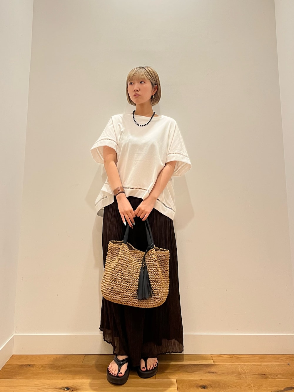 ブラウン系のスカート、ホワイト系のTシャツ/カットソー、ブルー系のネックレスを着用したレディースの夏コーディネートの1枚目の写真