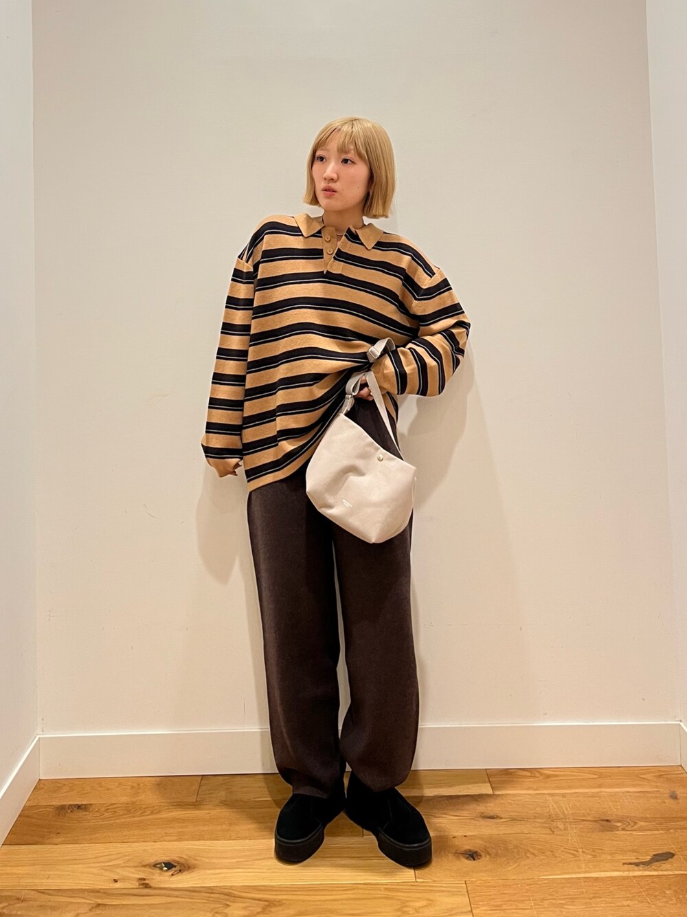 ブラウン系のニット/セーター、ブラウン系のその他パンツ、グレー系のショルダーバッグを着用したレディースの冬コーディネートの1枚目の写真