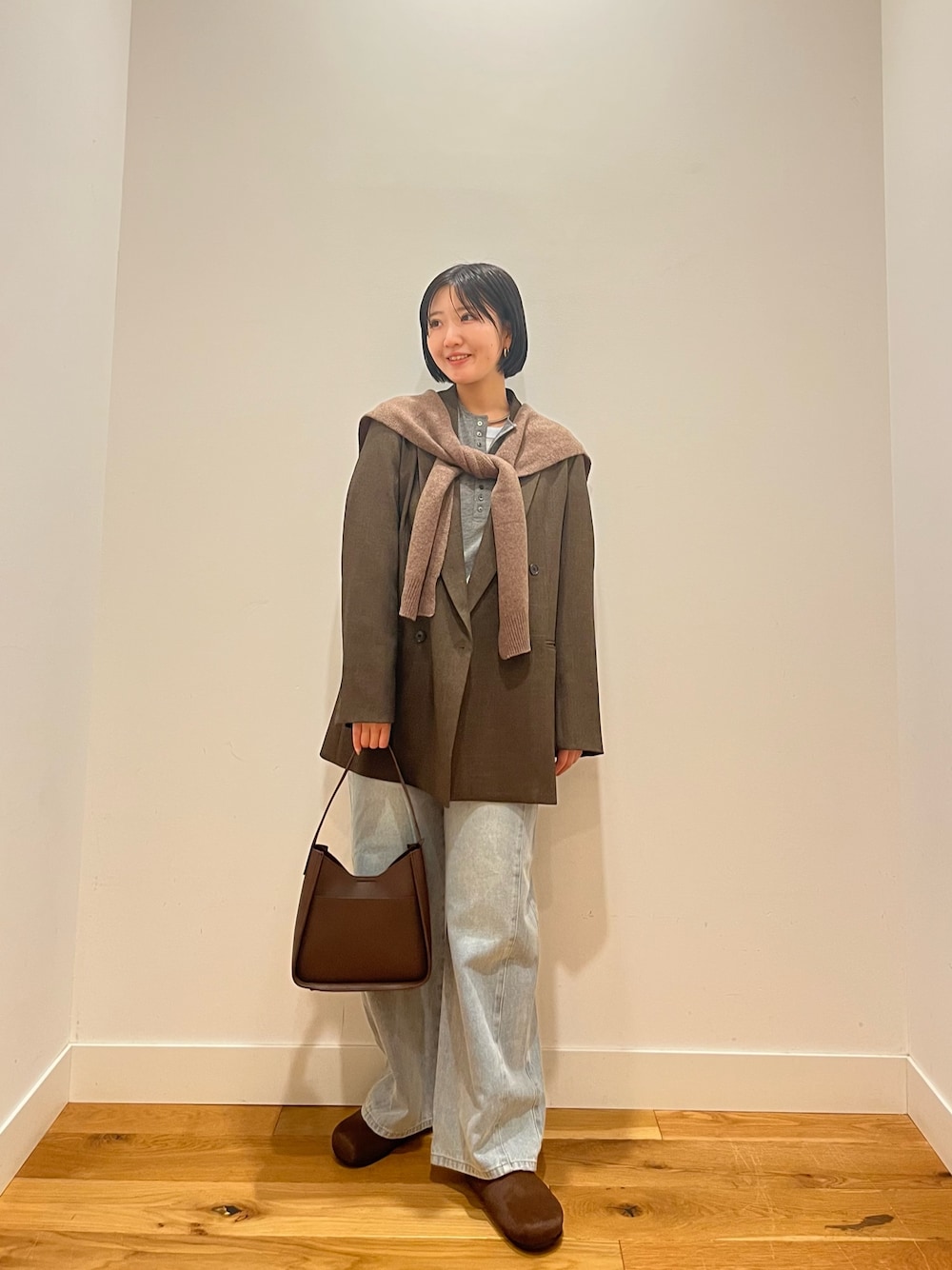 ブルー系のデニムパンツ、ブラウン系のその他アウター、ブルー系のTシャツ/カットソーを着用したレディースの秋コーディネートの1枚目の写真